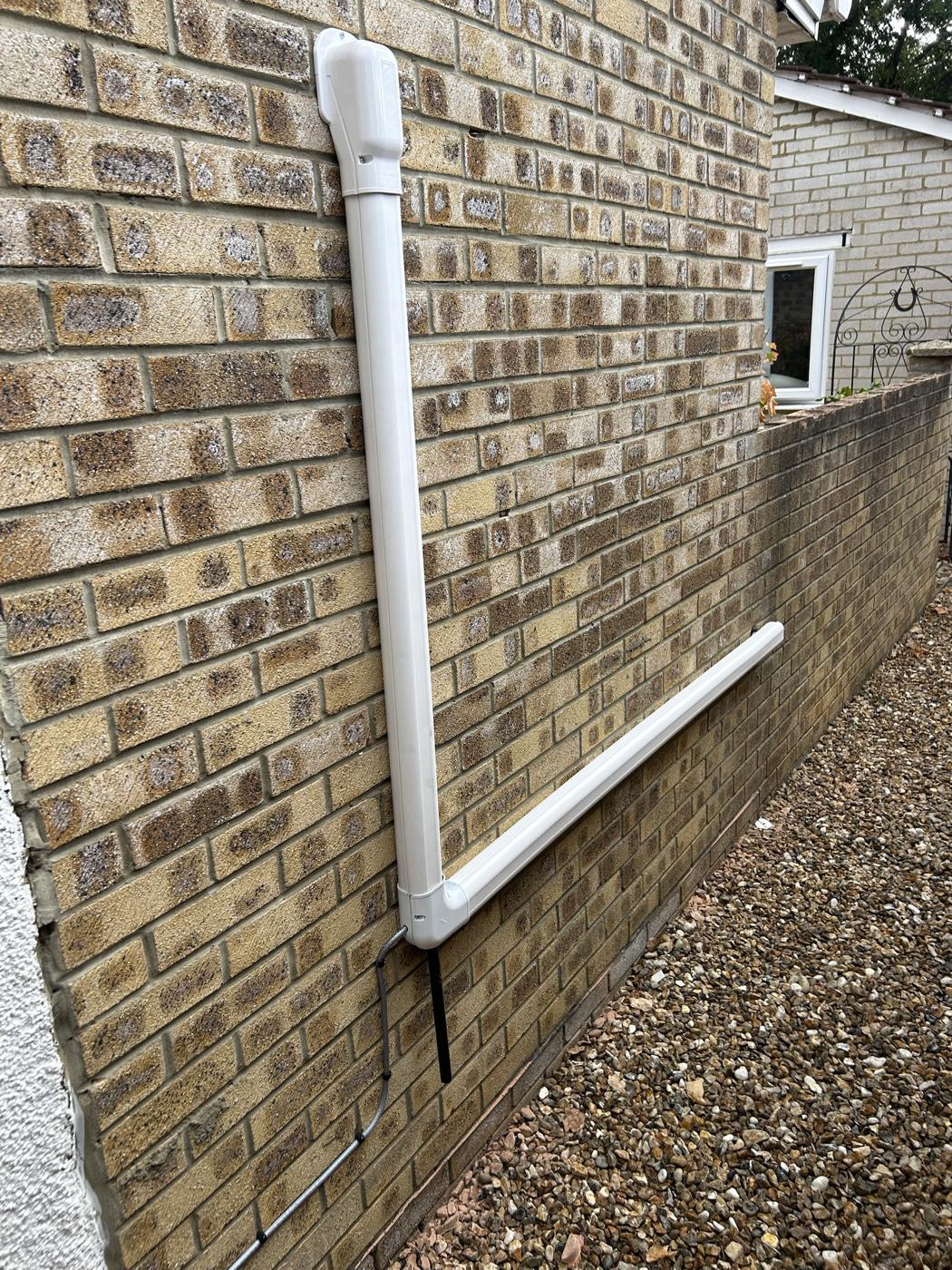 White trunking with formed bends on yellow stock brick